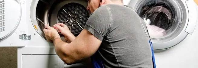 Dryer repair technician fixing a clothes dryer drum in Bakersfield, CA