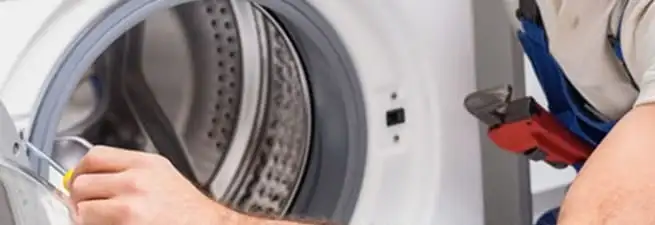 Appliance technician repairing a clothes dryer drum and internal parts in Bakersfield, CA