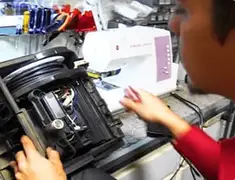 Vacuum repair technician servicing internal components on a workbench in Bakersfield, CA