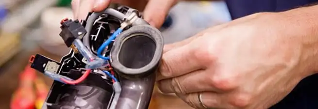 Vacuum repair technician reconnecting wiring and components in Bakersfield, CA