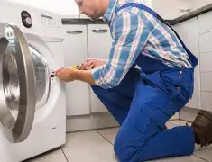 Washing machine repair technician servicing a front-load washer in Bakersfield, CA